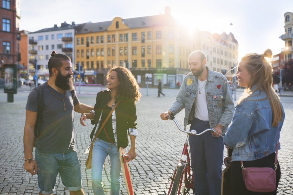 Fyra unga personer som står på ett torg