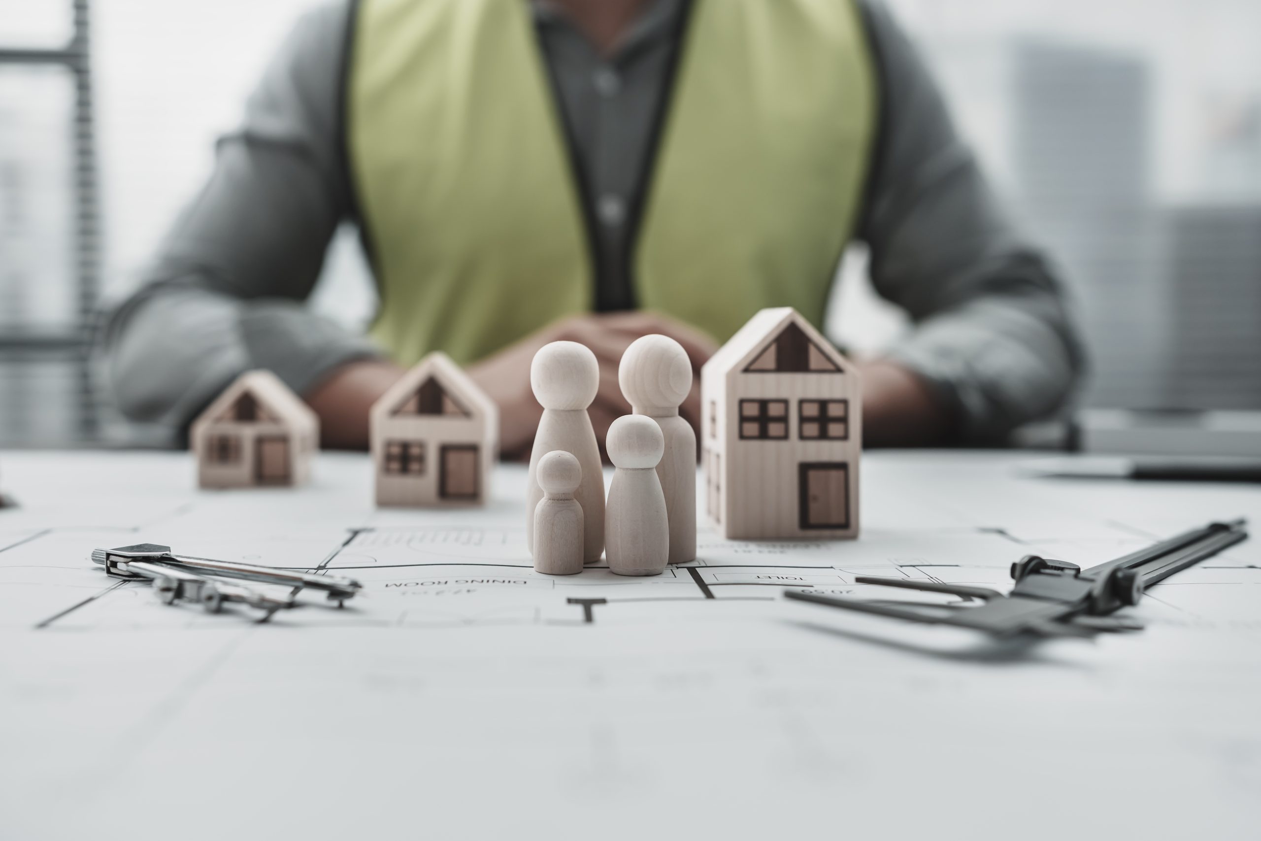 house model and wood doll repersent family on blueprint. Architect and engineer concept.